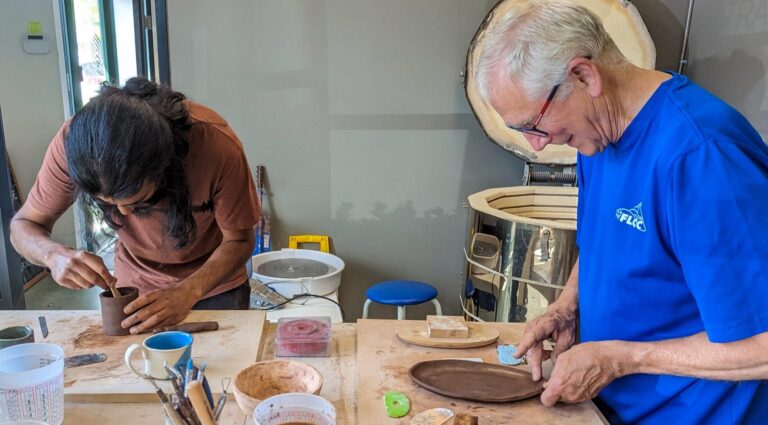 Two adults handbuilding pottery at Maker Cube in Langley, BC, shaping clay slabs for a sushi platter and a sauce dish using scoring and joining techniques