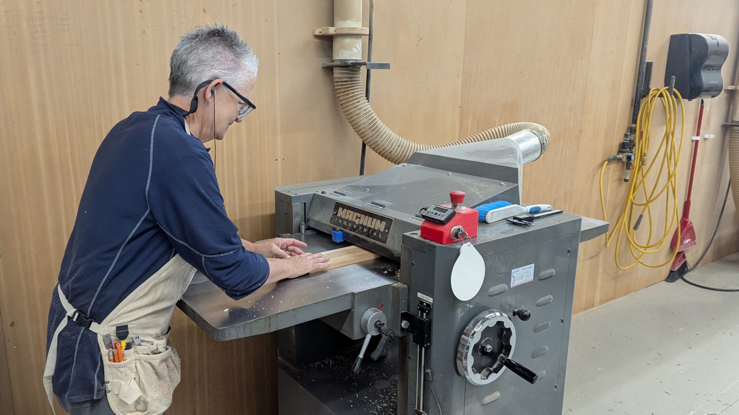 Member at Maker Cube in Langley, BC, feeding an eastern hard maple board through a 20 inch, three phase industrial planer to reach final thickness