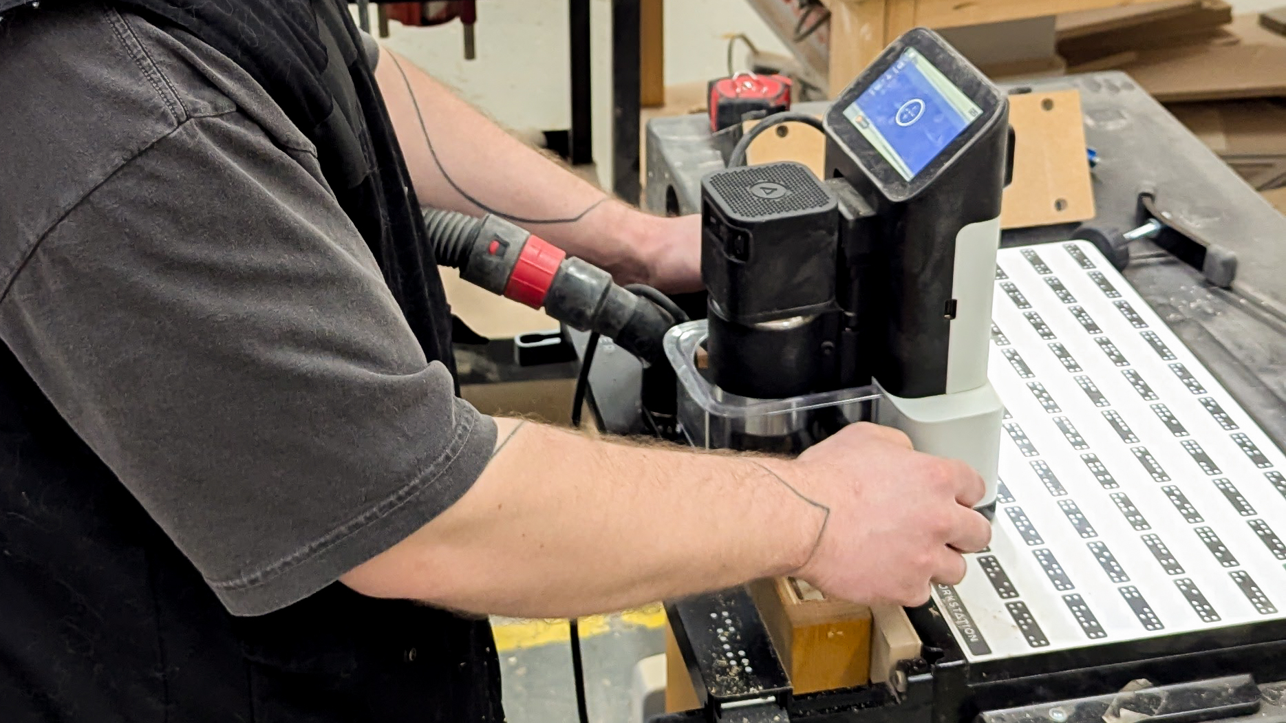 Shaper Origin handheld CNC cutting precise joinery on a workbench with positioning markers in a woodworking shop in Langley BC