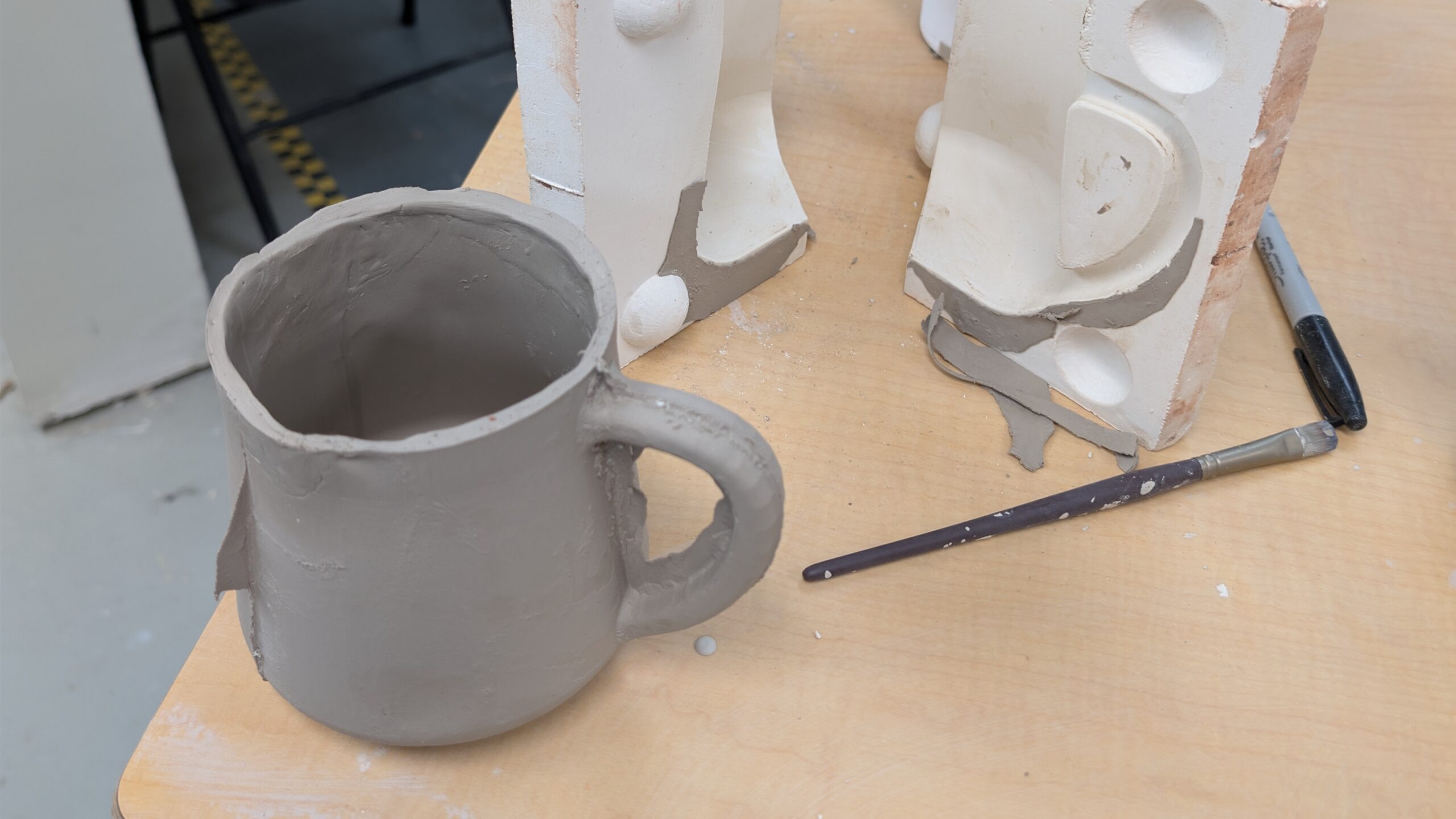 Slip cast ceramic piece beside plaster mold after demolding