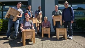 Maker Cube's cedar Planter box class participants in a group photo with their completed projects